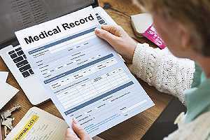 A healthcare provider checking a medical record report.One of the pros of Telehealth services saving time and money