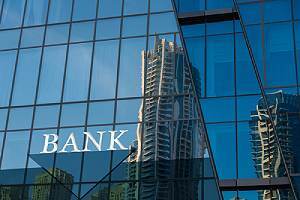 Bank sign on glass blue wall. Banks of all sizes need a strong cybersecurity strategy