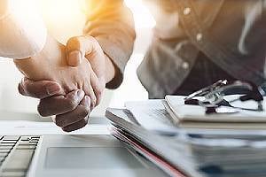 Business people shaking hands. An M&A advisory firm essentially acts as a middleman in a business sale transaction