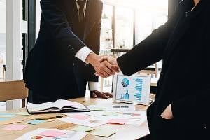 Business people shaking hands. Mergers and acquisitions often come with uncertainties