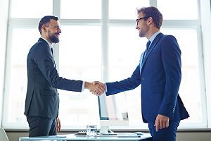 Client handshaking with a professional from a cybersecurity consulting firm