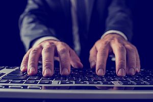 Closeup of a person typing on computer keyboard. Cybersecurity consulting firms have become a valuable resource