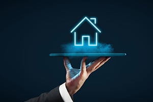 Person holding the concept of a house through a screen