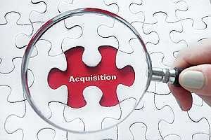 Magnifying glass over jigsaw puzzle. A merger or acquisition go through the process of due diligence