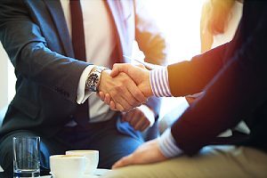 People shaking hands. Partnering with cybersecurity consulting firm can protect businesses