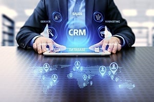 a business person holding a tablet with CRM software on it