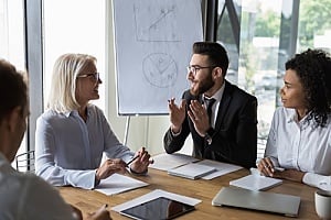 a group of executives speaking with an outsourced CIO during a business meeting