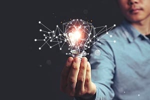 an employee holding a lightbulb representing innovation