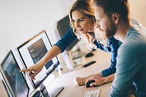 an IT leader showing an employee how to manage a certain type of task