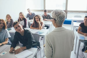 Teacher in college classroom talking to students