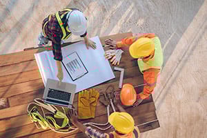 Construction workers planning and working on laptop