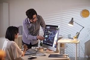 Employee pointing out risks on monitor 