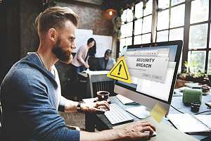 Employee with security breach on monitor 