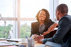 two employees discussing the importance of being cyber aware and cybersecurity best practices