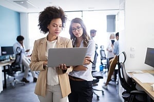 Employees looking at laptop in office