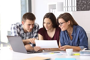 employees looking over notes to decide which cyber risk management firm to hire