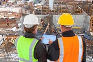 engineers on construction site with tablet