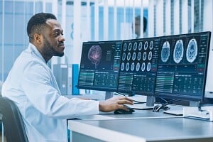 health data scientist working on his workstation to review CT brain scan healthcare technology