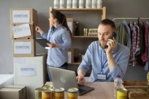 man on phone and women checking donation boxes