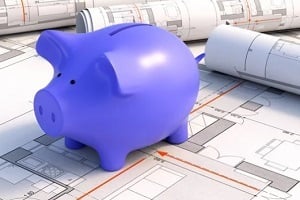 piggy bank on construction project blueprint