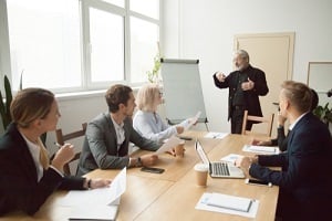 senior company leader presenting employees new corporate plan