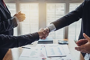 two business owners shaking hands after a successful software contract negotiation
