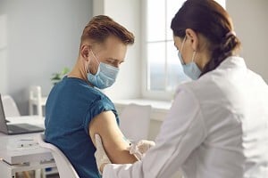 young man participating in a clinical trial with a physician